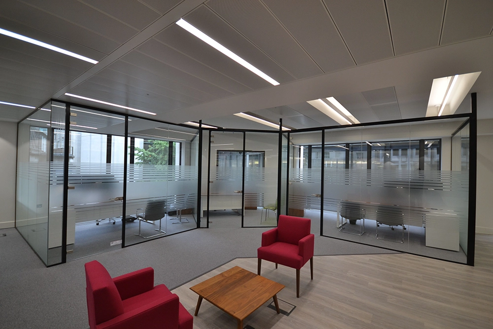 Office refurb | Modern office area with glass partitions and red chairs, wooden table