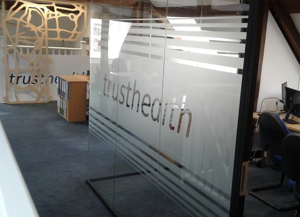 Office refurbishment Sussex | Frosted glass partition with "Trustedhealth" written on them