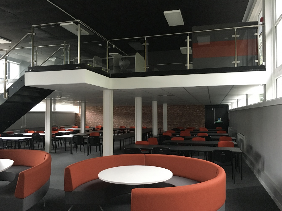 What is a mezzanine floor | Retail mezzanine floor in a lounge area with red circular seats.