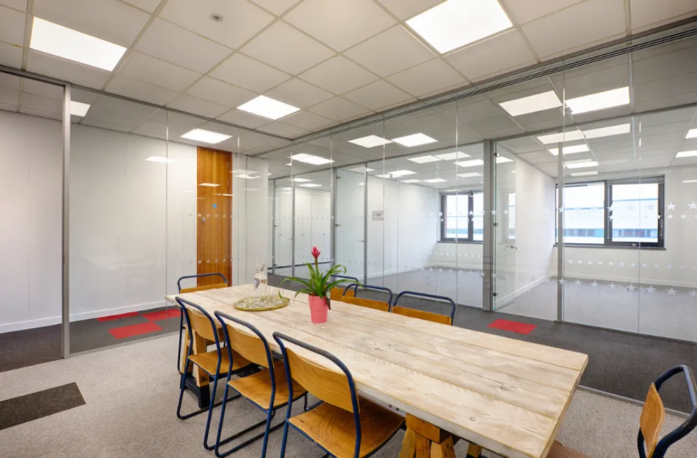 office fit-out | Modern office space with meeting table and glass wall partitions.