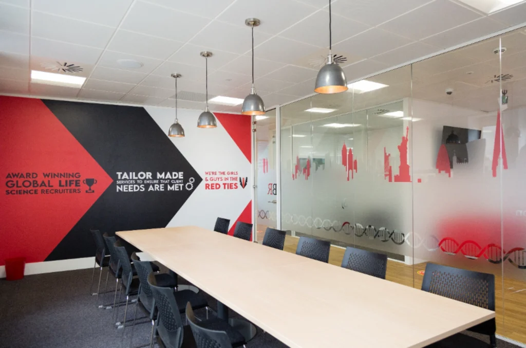 Office refurbishment companies | Boardroom with custom branding and glass walls.